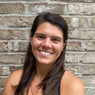 Tanner Ruberg smiling in front of a brick wall.